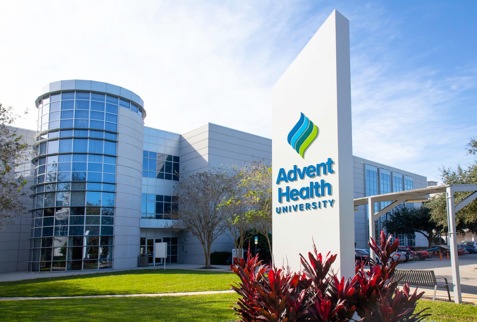 Photograph of a modern building with a sign in front reading "Advent Health University"