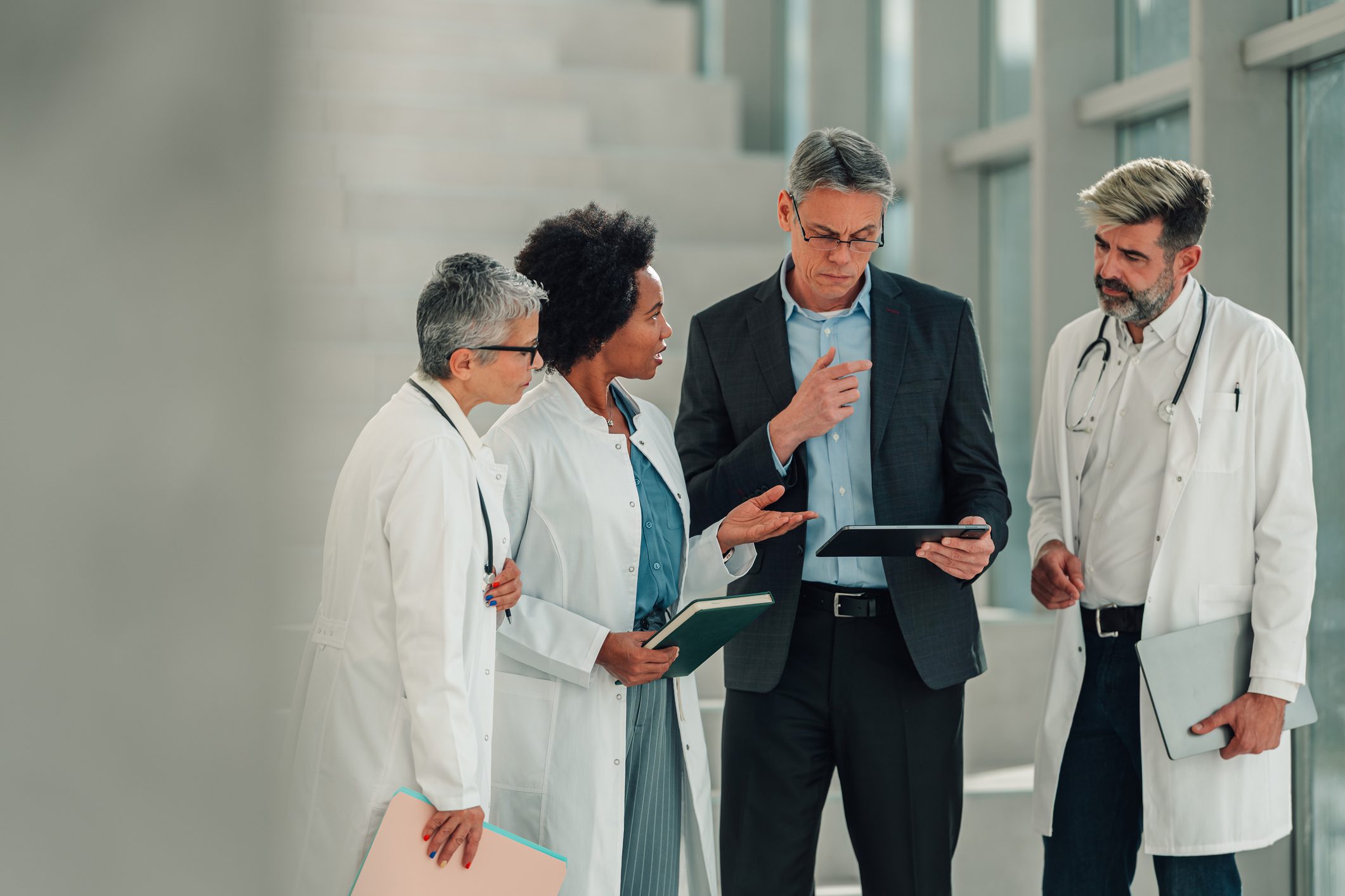 Healthcare professionals discussing medical data on tablet stock photo